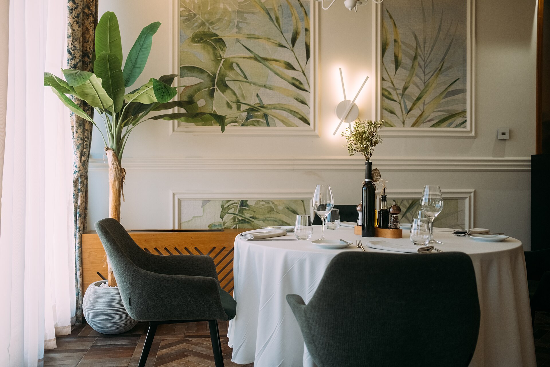 A grand private dining room with tall windows and chandeliers